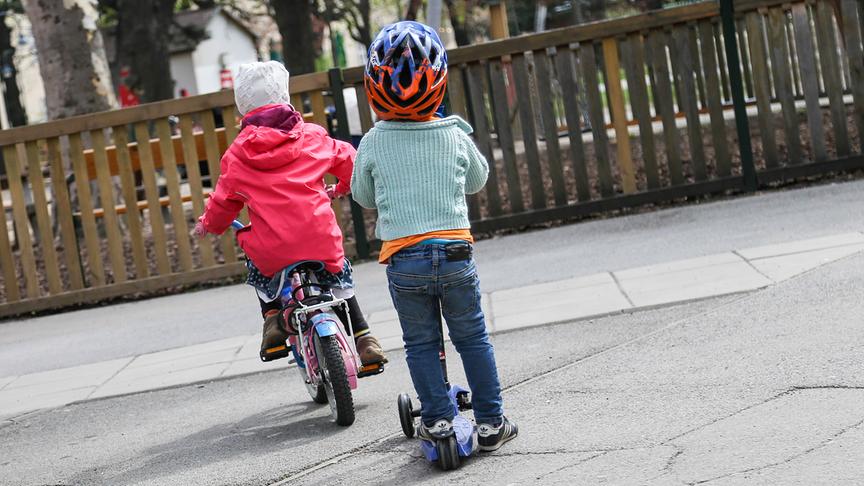 Sport und Freizeit: Kinder mit Roller und Fahrrad 